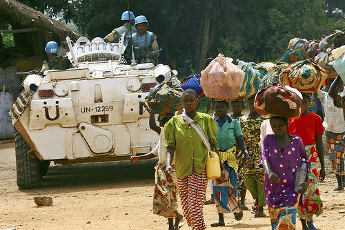 Villagers pass a UN patrol unit in DR Congo