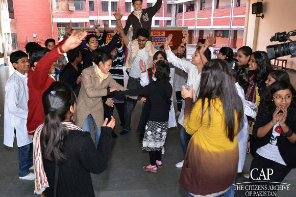 Indian and Pakistani students dancing together after they meet for the first time after a 16-month exchange in Delhi