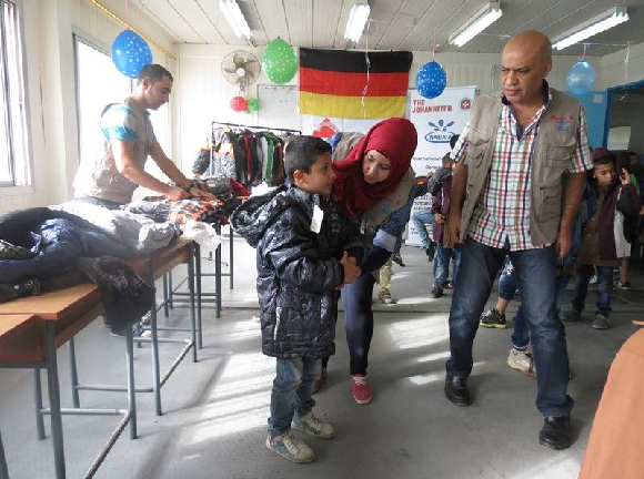 Providing clothes to children. Image Credit: Naba'a 